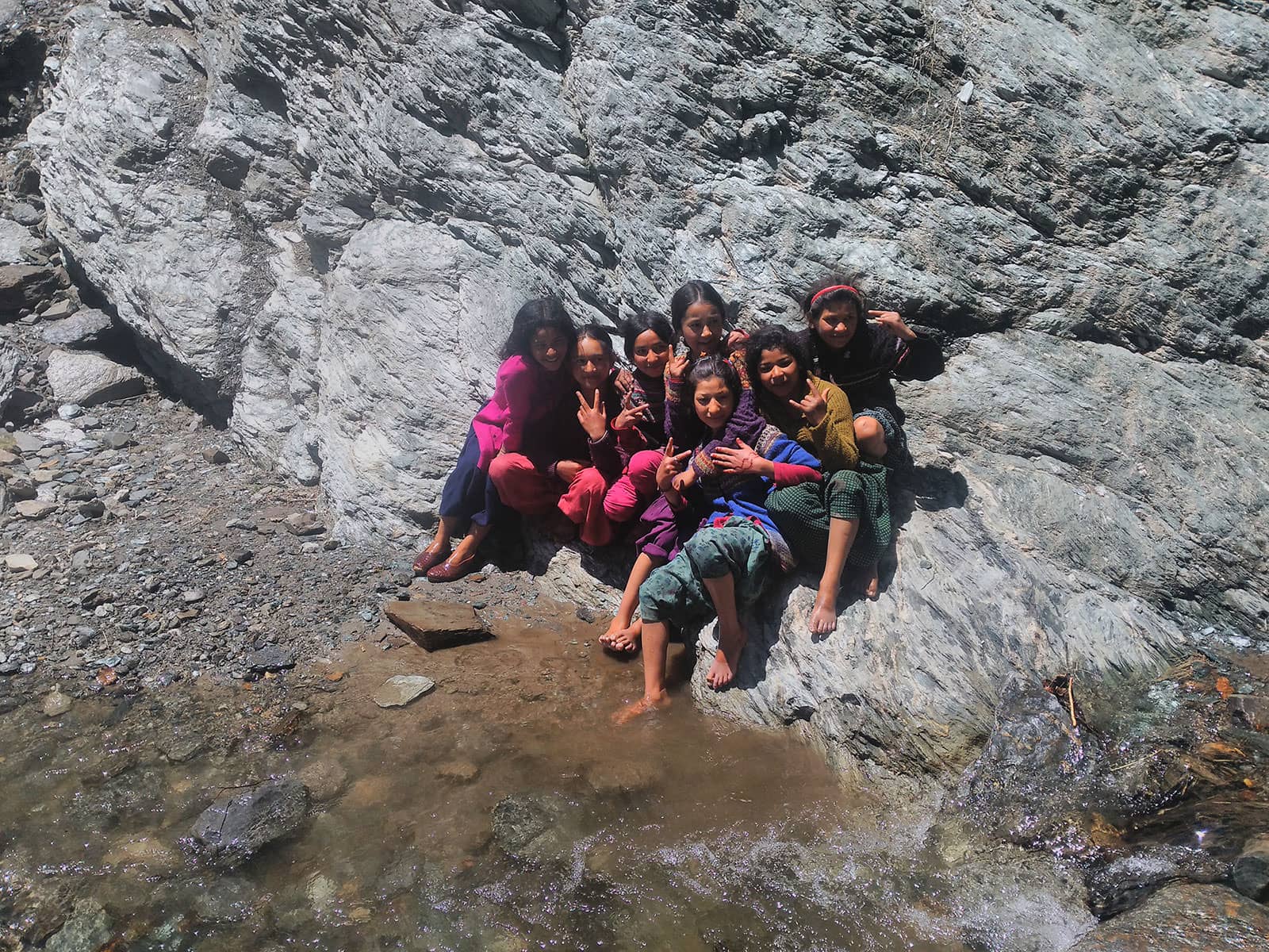 Little girls playing near a stream